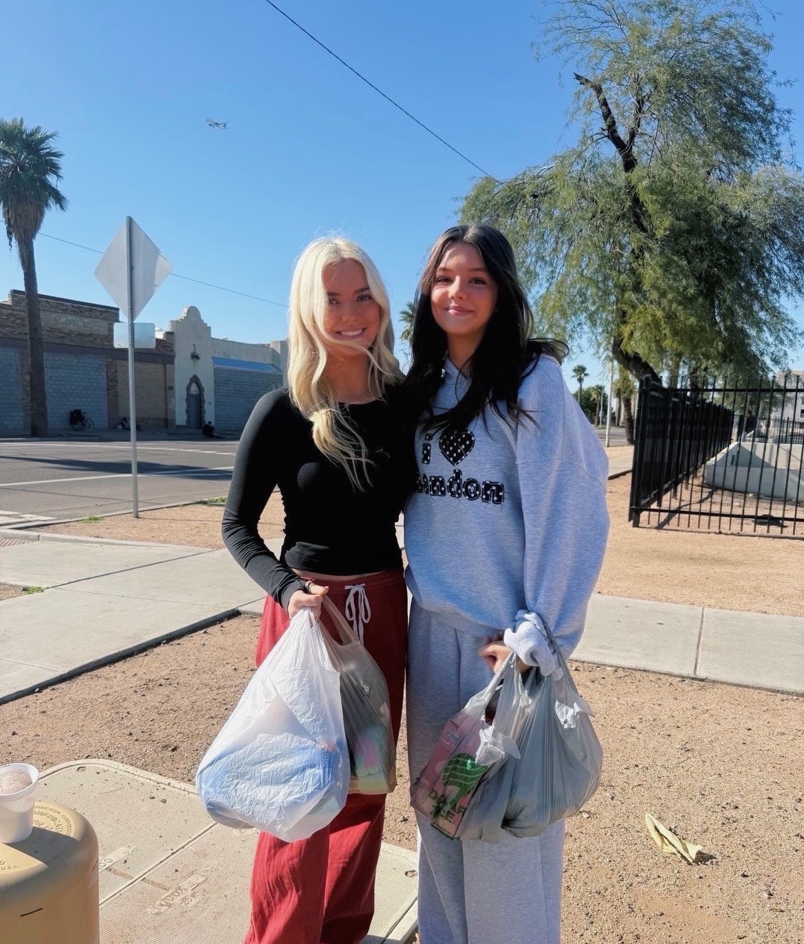 Two women holding bags street portrait