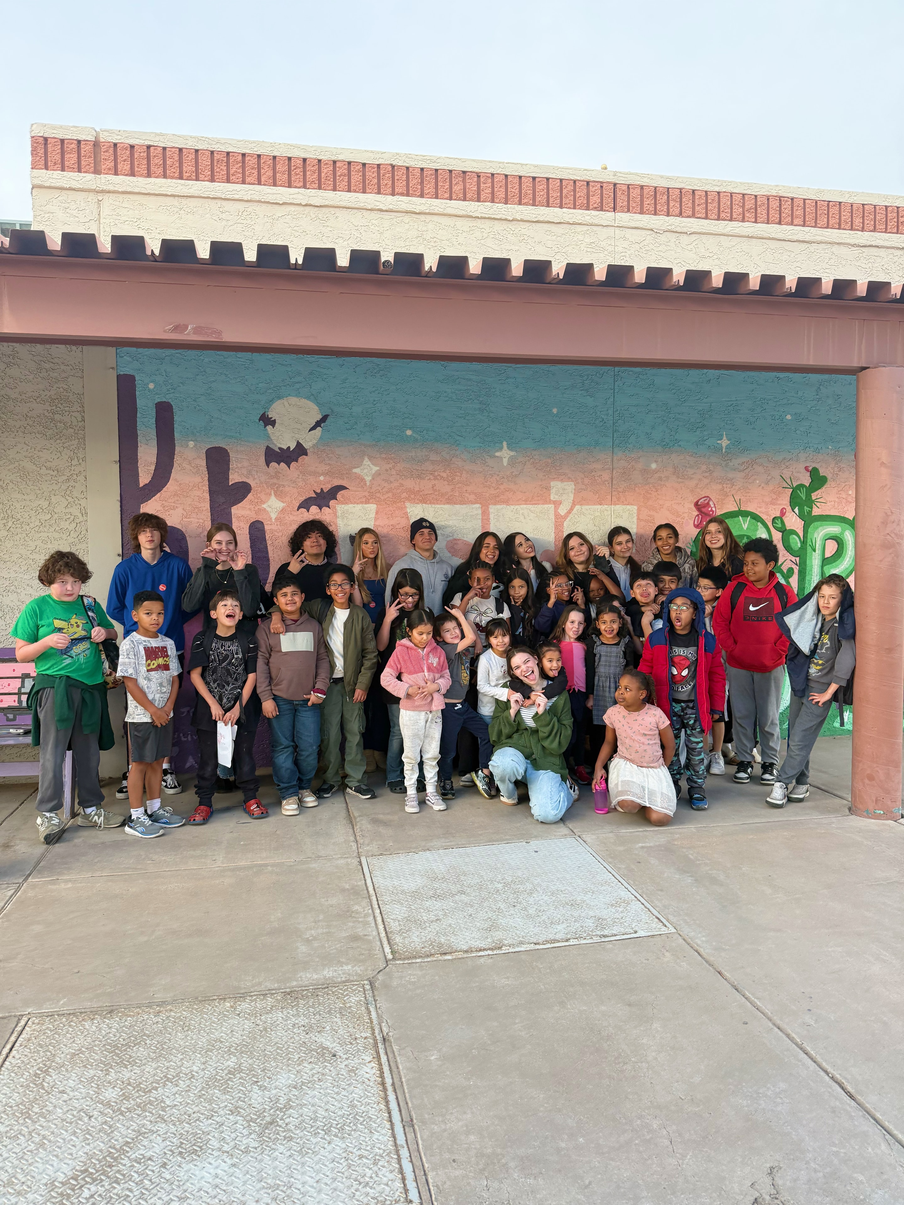 Large group of children posing at mural wall